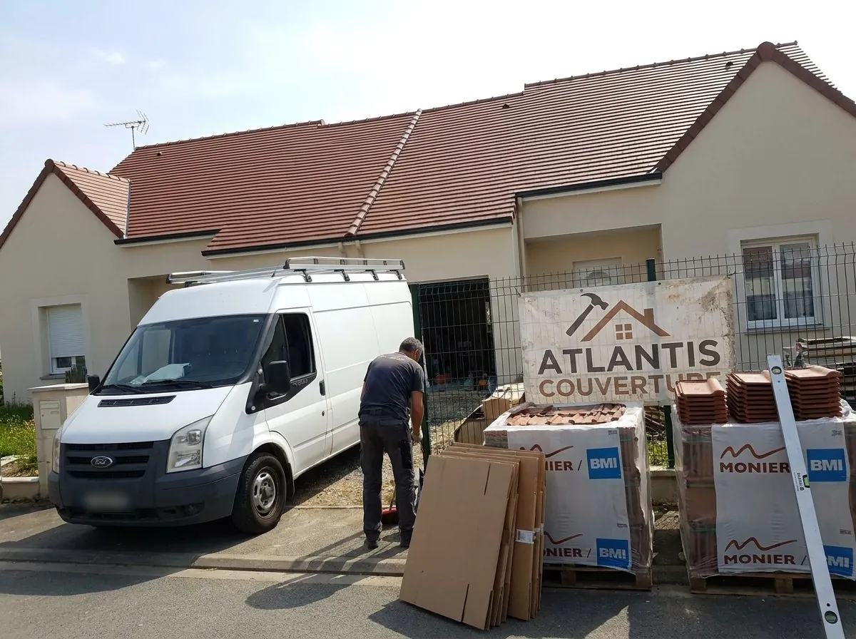 Pavillon à Saint-Herblain après réfection de la couverture en tuiles par Atlantis Couverture, bâche de l'entreprise et palettes de tuiles devant la clôture