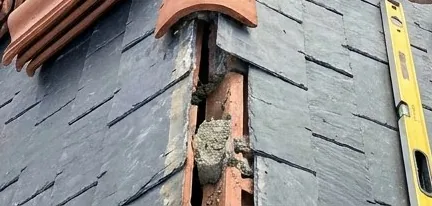 Tuiles faîtières neuves posées près du faîtage ouvert sur un toit en ardoise à Saint-Herblain, niveau de couvreur